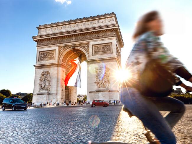 Una ciclista pasa por delante del Arco del Triunfo.