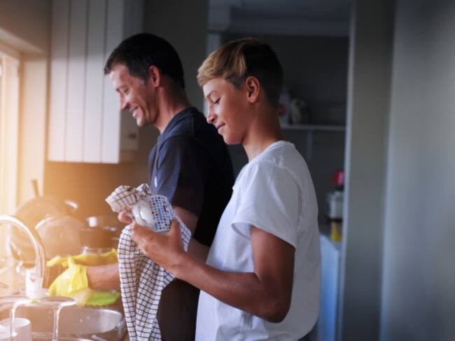 Un padre y su hijo realizando las tareas del hogar