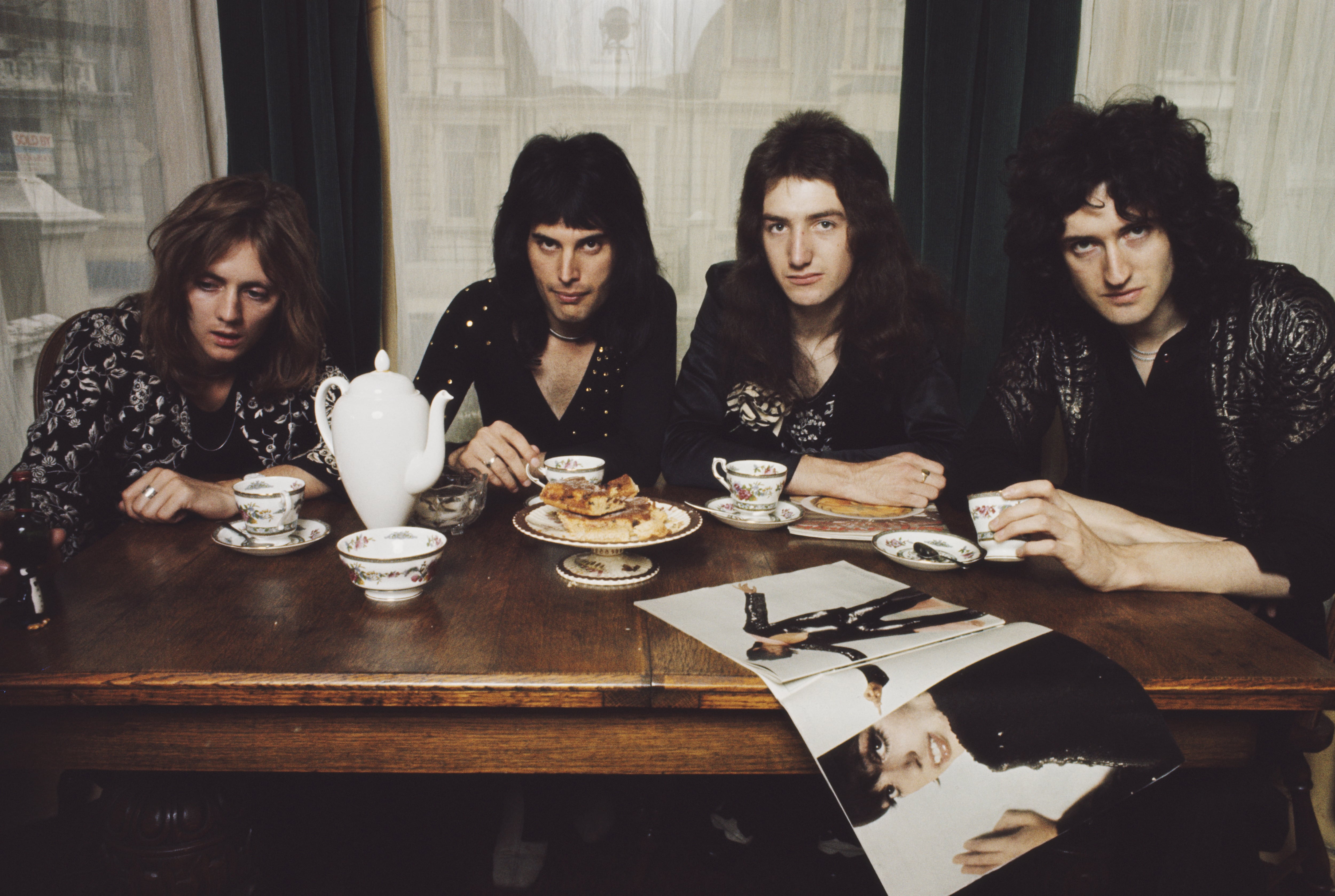 LONDRES - 1 de enero: El grupo de rock británico Queen posa en una mesa de comedor en el apartamento del vocalista Freddie Mercury, en Holland Road, West Kensington, Londres, a principios de 1974. De izquierda a derecha: Roger Taylor, Freddie Mercury (1946-1991), John Deacon y Brian May. (Foto de Mark Hayward Archive/Redferns)