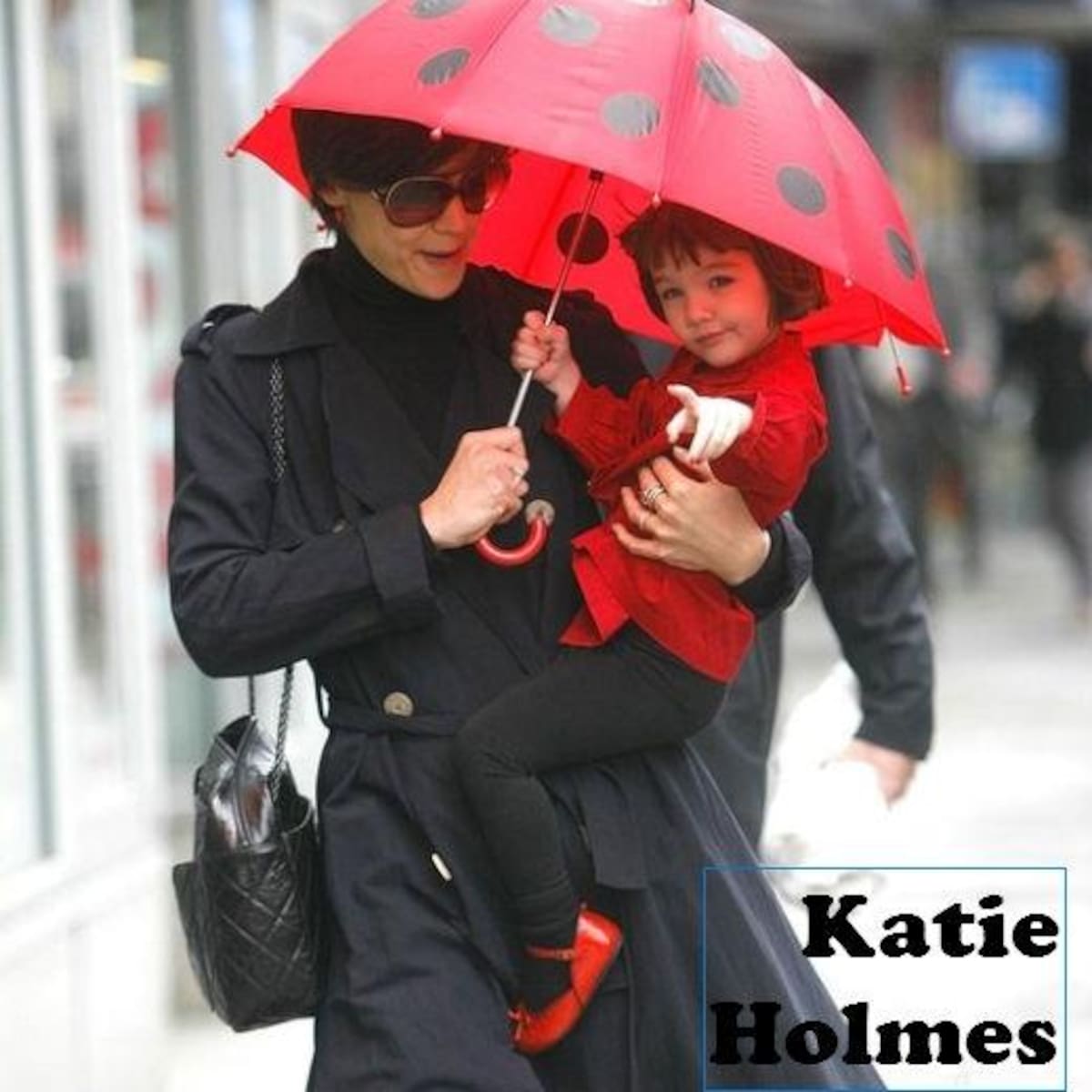 Muy divertida Katie Holmes con su hija Suri Cruise. El paraguas es de lo más chi, rojo y negro imitando a una mariquita