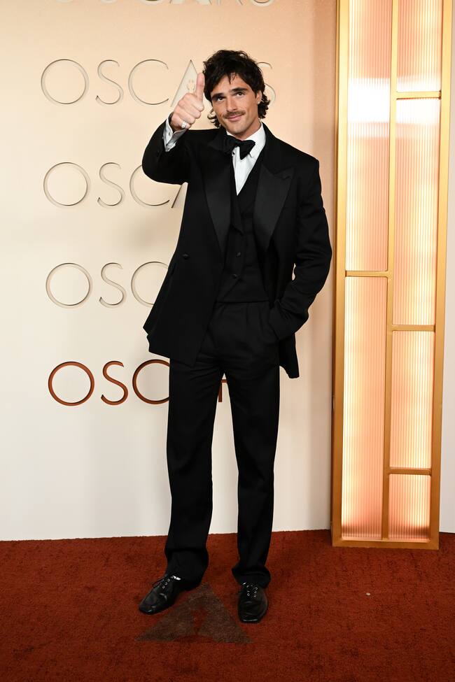 Nominado a mejor actor de reparto por Frankenstein, Jacob Elordi llegaba con su firma de cabecera esta temporada: Bottega Veneta. Elegante esmoquin negro tres piezas con solapa de raso, chaleco con doble botonadura y zapatos de cordones negros.