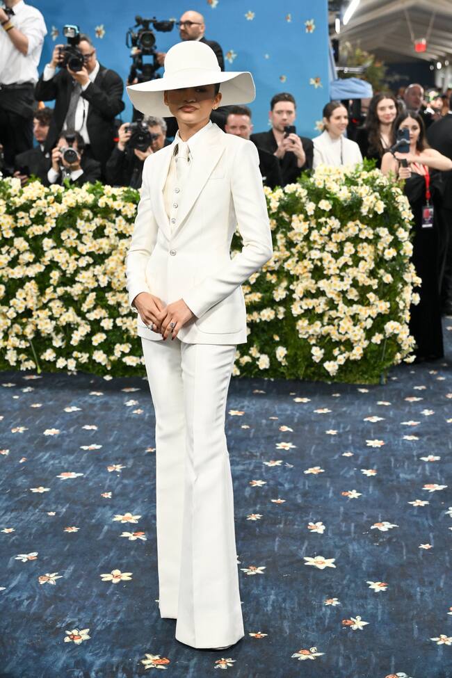 El traje sastre era protagonista en la alfombra y Zendaya ha optado por uno a medida total White de Louis Vuitton firmado p por Pharrell Williams. Tacones y sombrero de ala ancha y atención al rojo de la manicura.
