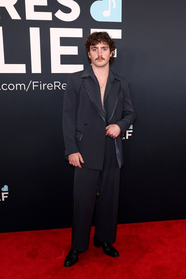 Las estridencias las deja para sus actuaciones sobre el escenario, en la alfombra, Benson Boone, optó por un traje negro de inspiración setentera hecho a la medida por Dolce & Gabbana.