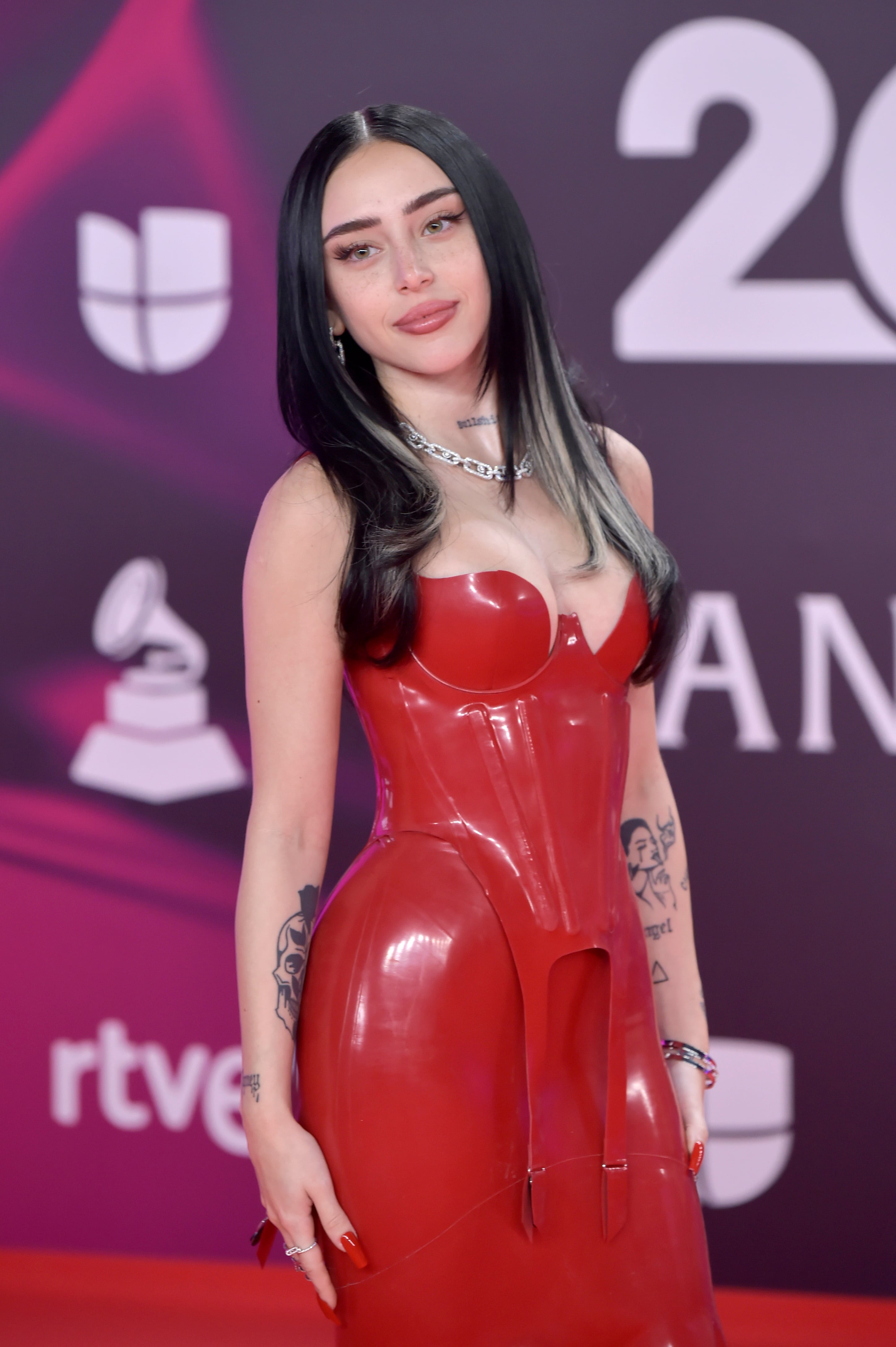 Nicki Nicole apostó por este vestido largo de inspiración en efecto vinilo rojo que se ceñía a su piel como un guante. El detalle del escote con forma de corazón nos mató...