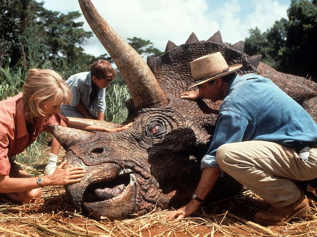 Laura Dern y Sam Neill en la conocida escena del triceratops en 'Parque Jurásico', de 1993. / Universal/Getty