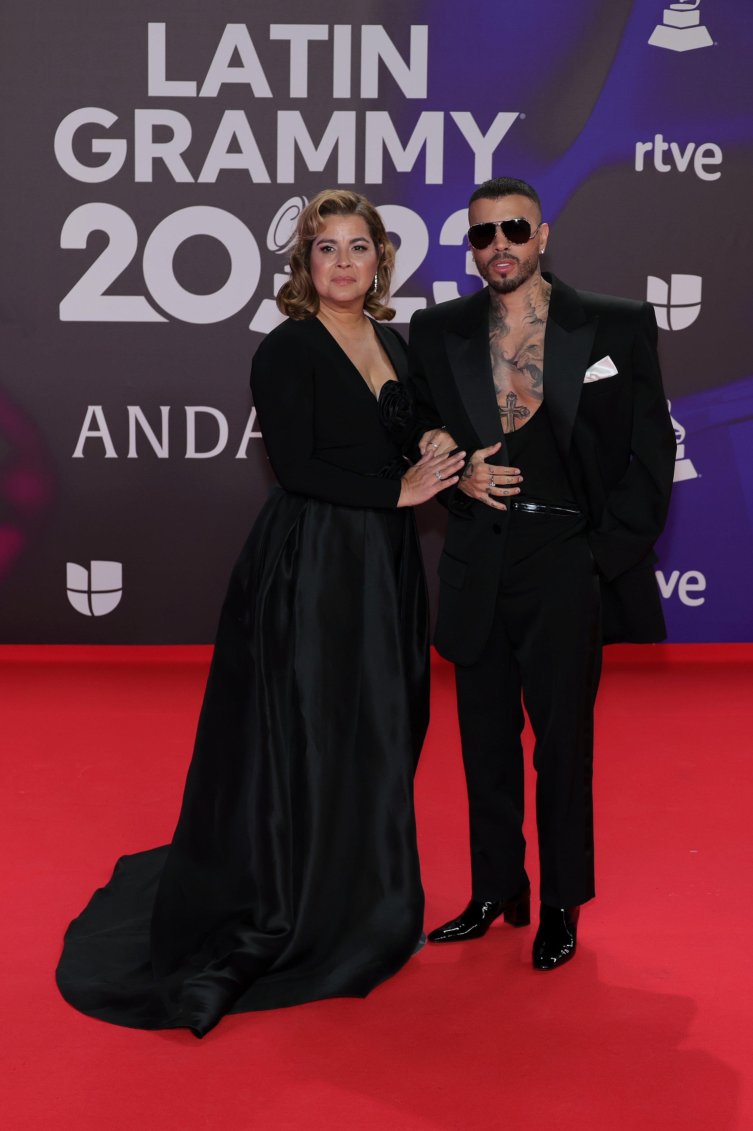 Rauw Alejandro ha dejado de posar en las alfombras con Rosalía, pero lo hace con una persona más importante para él: su madre. Eso sí, ya le podían haber puesto algo de color a sus outfits.