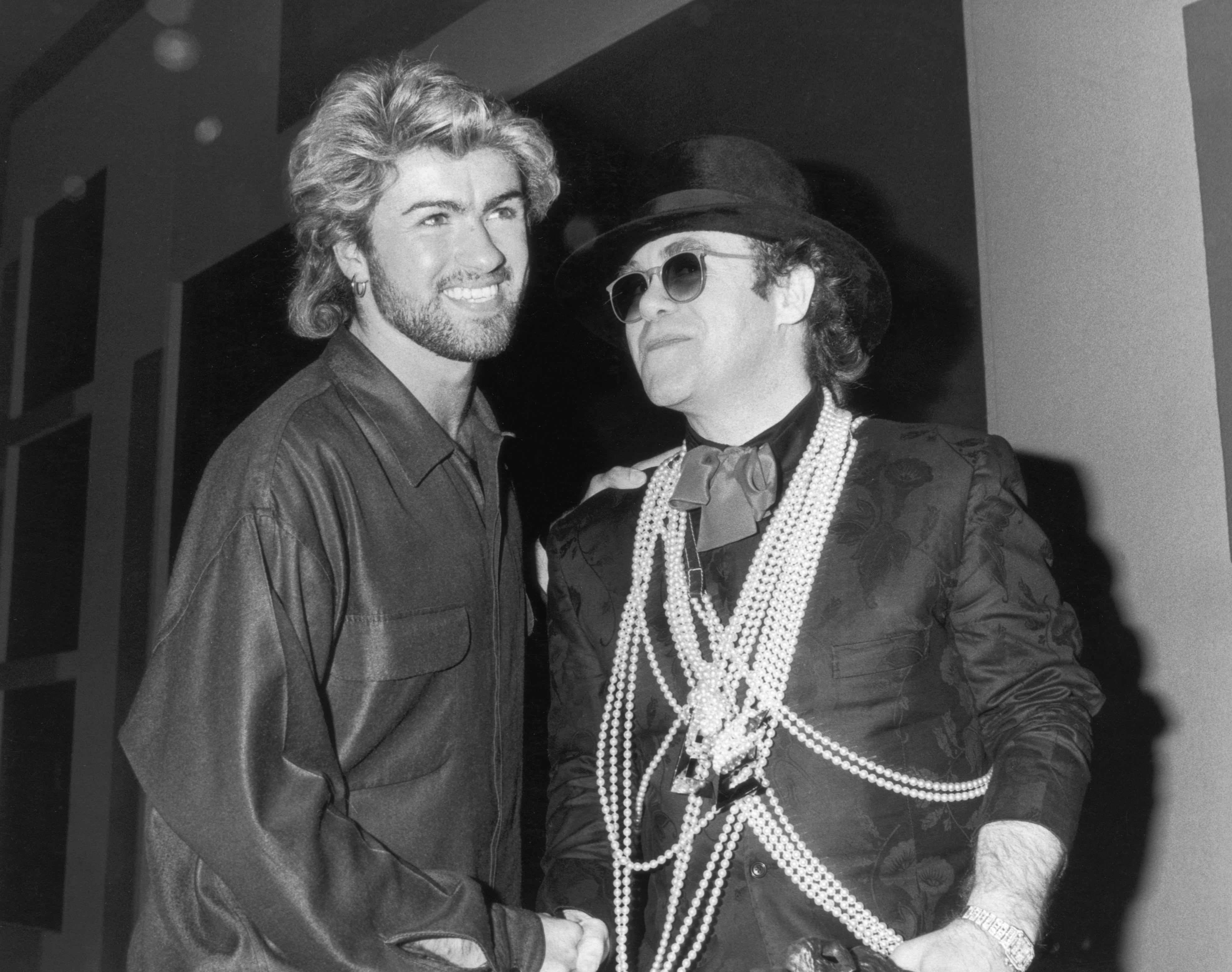 Elton John felicita a George Michael por ganar el premio Ivor Novelloal al Compositor del Año en el Grosvenor House Hotel de Londres