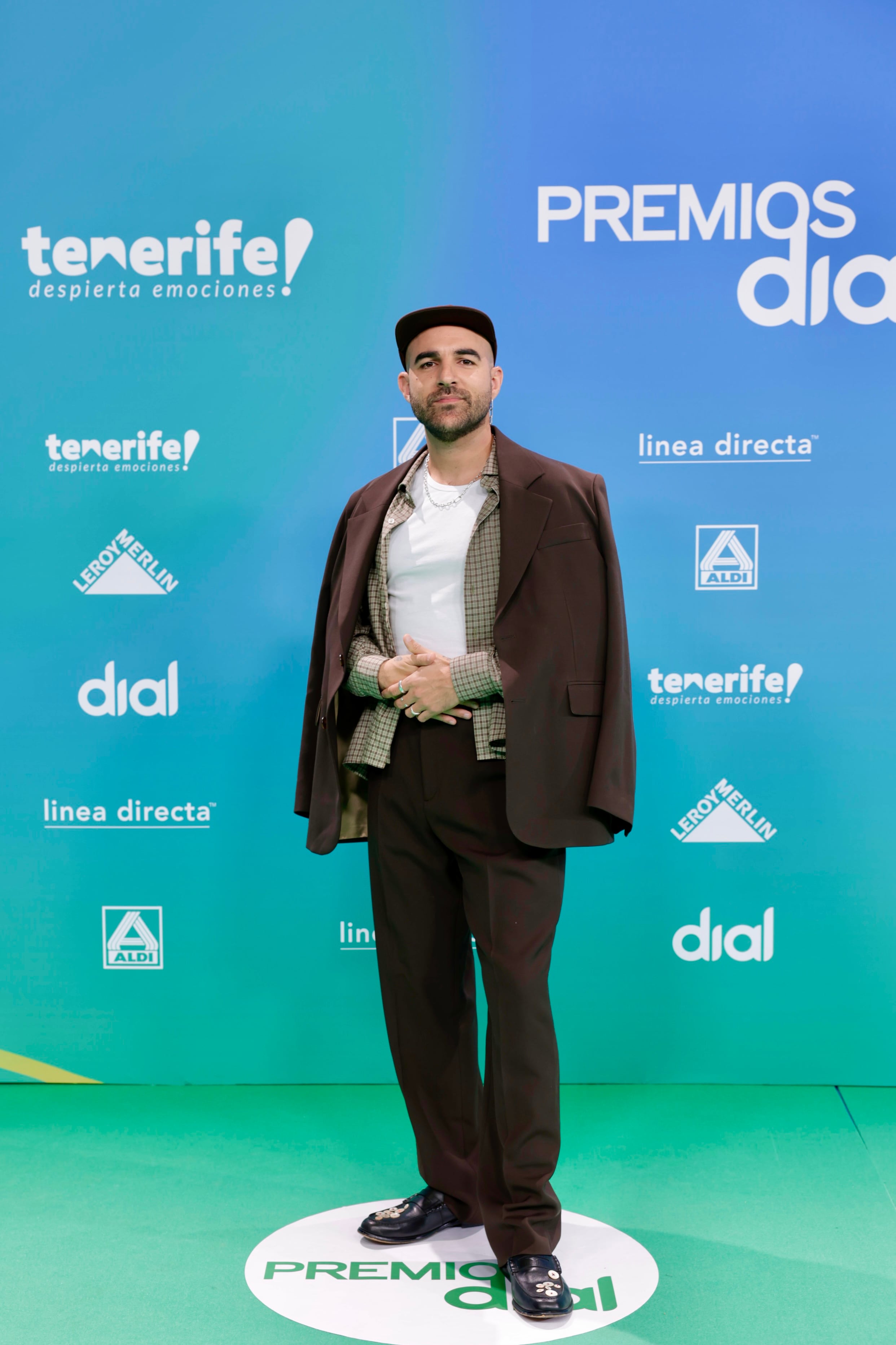 A capas y muy conjuntado en tonos marrones con la blazer sobre los hombres. Poco práctico para cantar, pero ya dejaba claro que habría cambio de vestuario para subirse al escenario. Y atención a los mocasines con botones, que no, no los ha cosido él, aunque reconoció que no se le da mal lo de coser.