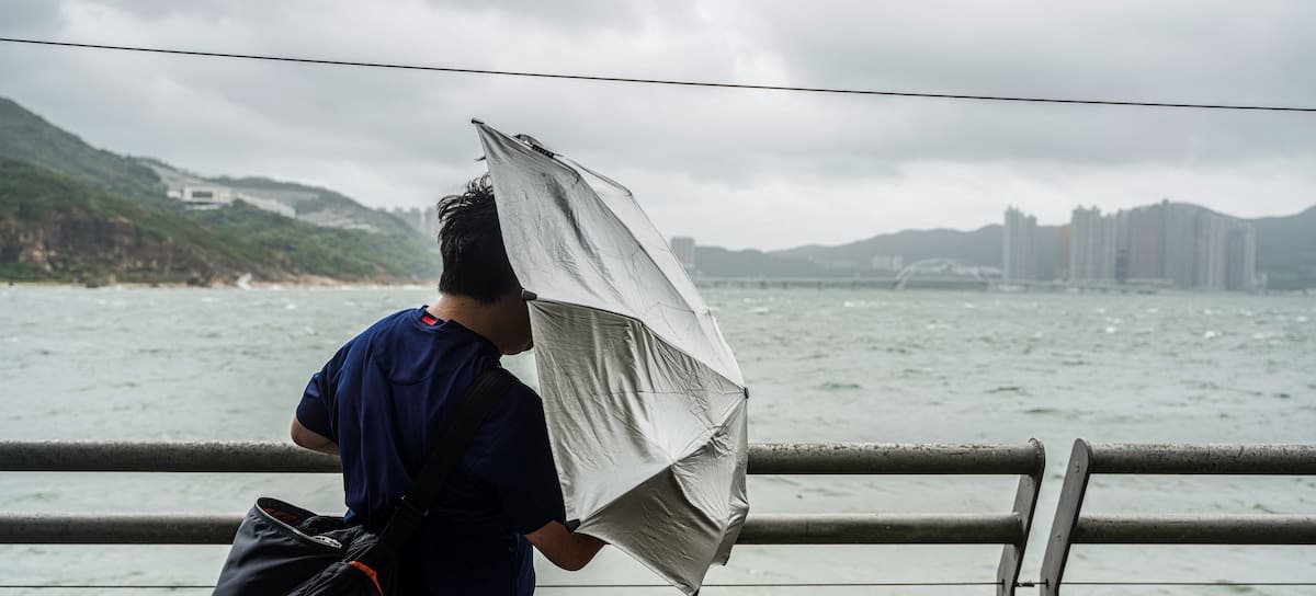 Persona sujetando un paraguas en medio de la tormenta.