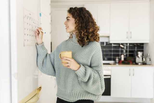 Una mujer escribe unas anotaciones en el calendario.