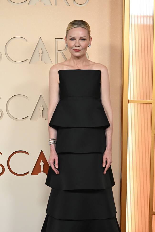 Kirsten Dunst llegaba con un vestido de corte simétrico de la firma neoyorkina Khaite en negro compuesto por seis volantes superpuestos.