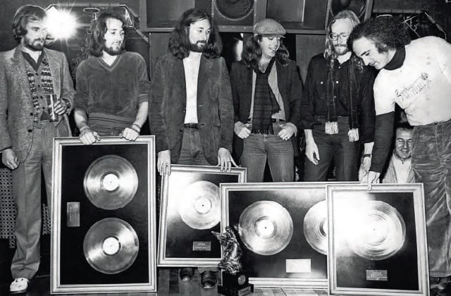 Luqui (a la derecha) entrega un disco de oro a la banda Supertramp