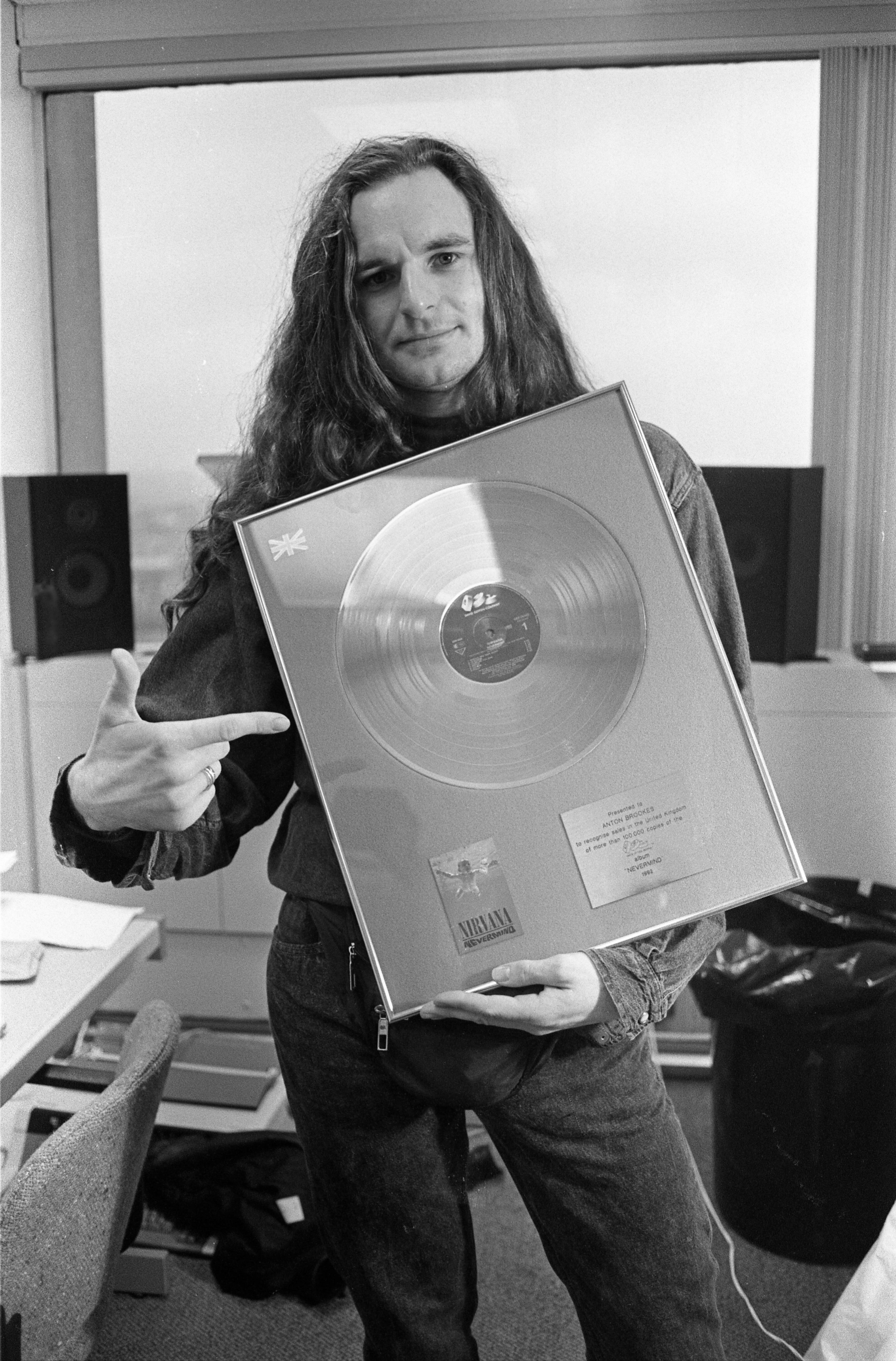 Anton Brookes, publicista de Nirvana en el Reino Unido, de Bad Moon PR, sosteniendo un disco de oro de EMI por las 100.000 copias vendidas del álbum 'Nevermind' de la banda, Reino Unido, 2000. (Foto de Martyn Goodacre/Getty Images)