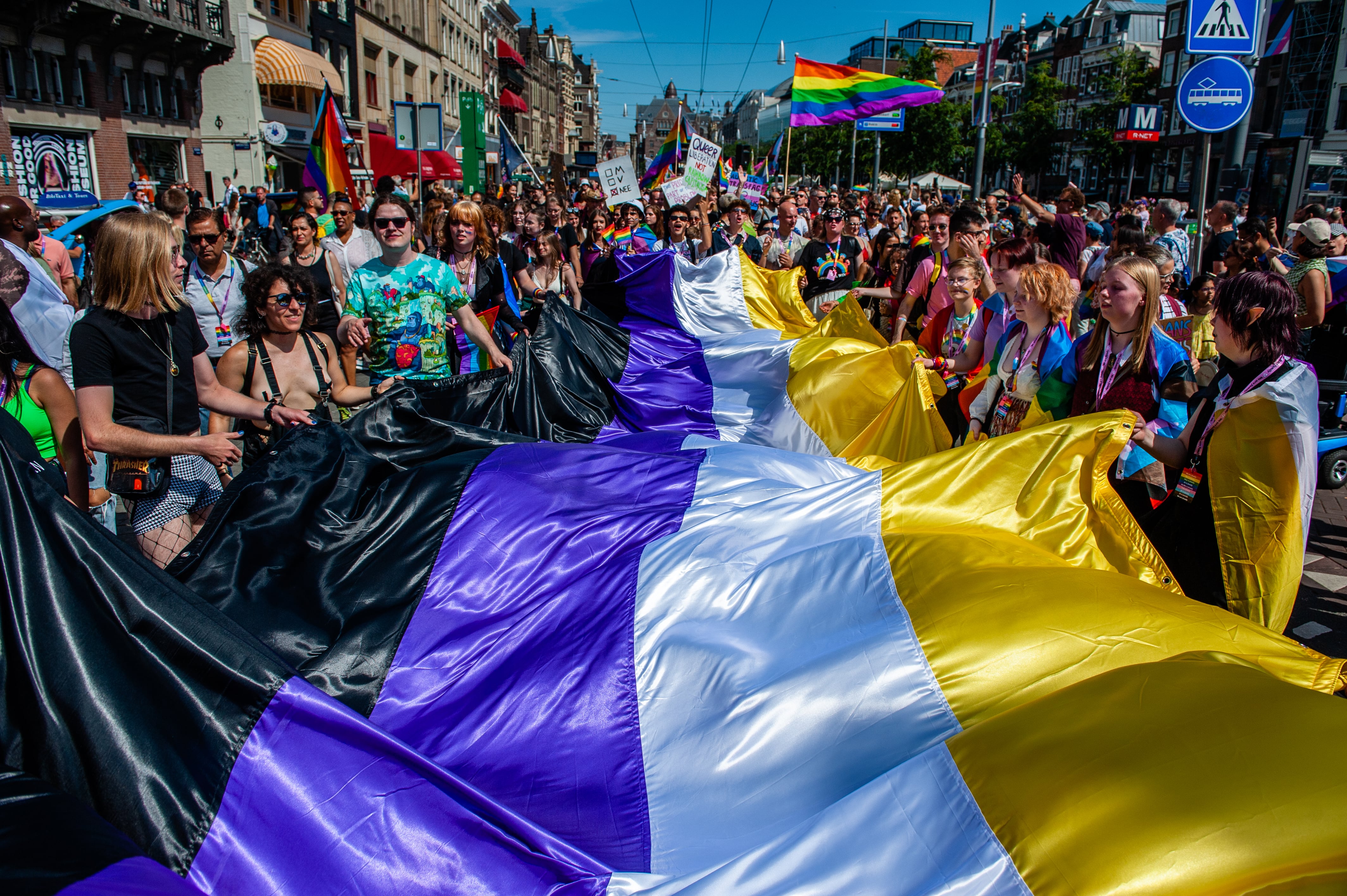 Gente con una gran bandera del género no binario en Ámsterdam. Getty.