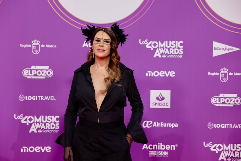 La actriz Karla Sofía Gascón en LOS40 Music Awards Santander 2025 le ha dado el protagonismo de su look a un tocado dorado con plumas en negro.