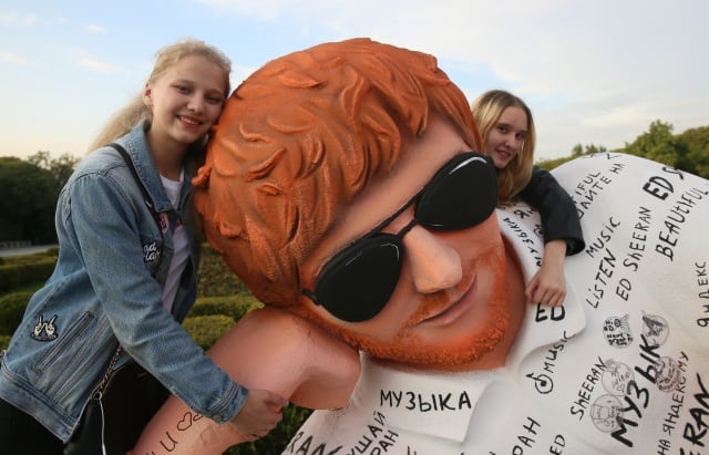 Fans posan junto a la estatua de Ed Sheeran