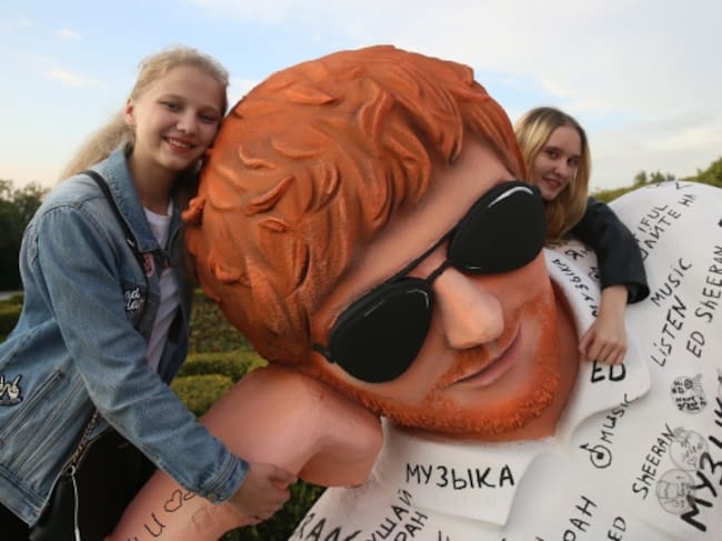 Fans posan junto a la estatua de Ed Sheeran