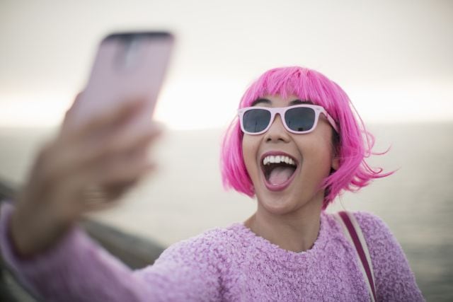 Una joven se toma un selfie en mitad de la calle.