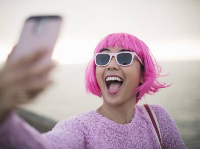 Una joven se toma un selfie en mitad de la calle.