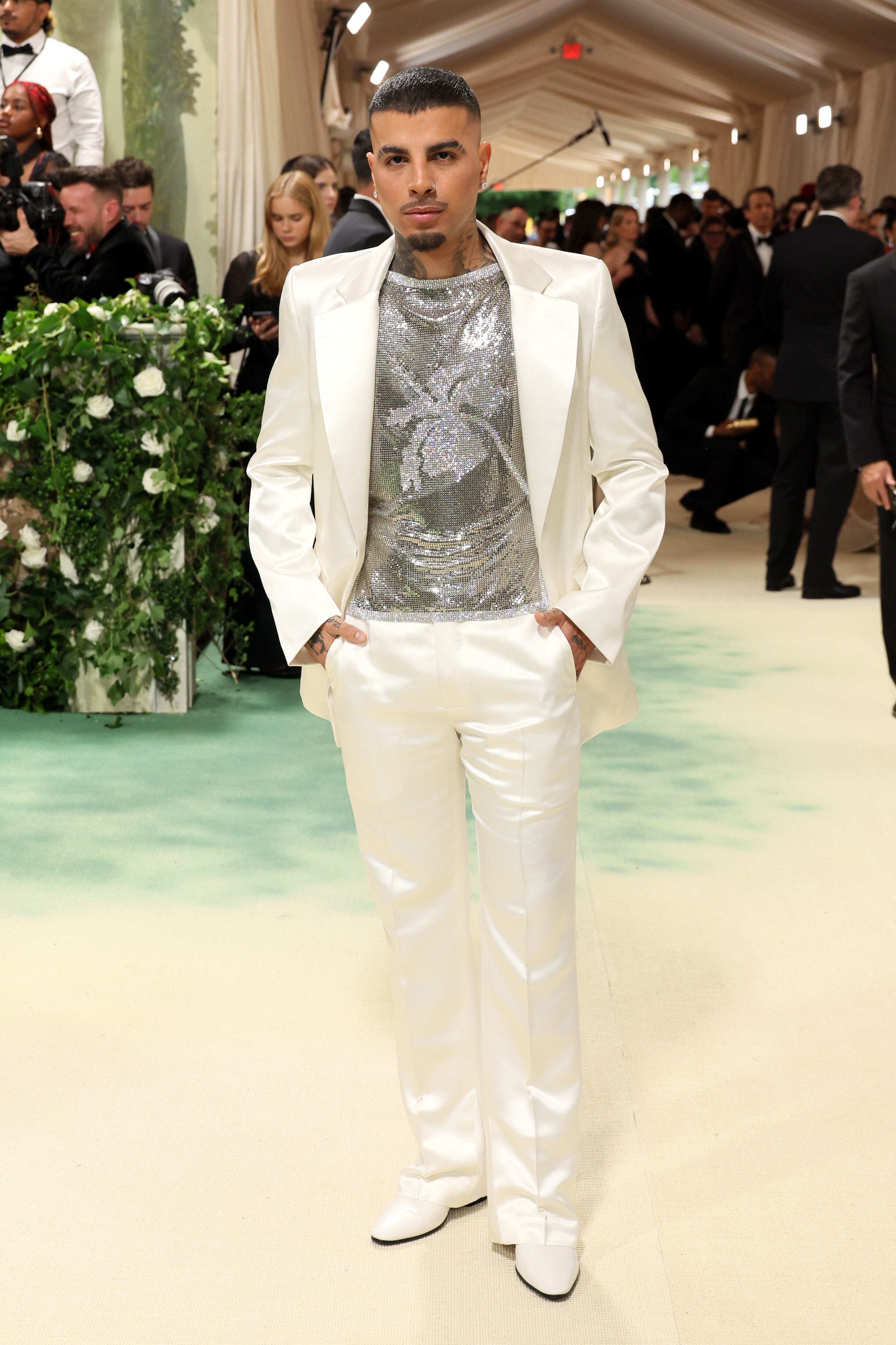 Antes de Rosalía, habíamos visto a Rauw Alejandro con un traje ajustado, no tan holgado como los que suele llevar, firmado por Ludovic de Saint Sernin confeccionado con seda y algodón y hecho a medida. El tema del evento, ‘el jardín del tiempo’, lo daba su top sin mangas lleno de cristales de Swarovski formando el dibujo de una Flor de Maga que es la flor nacional de su Puerto Rico natal.