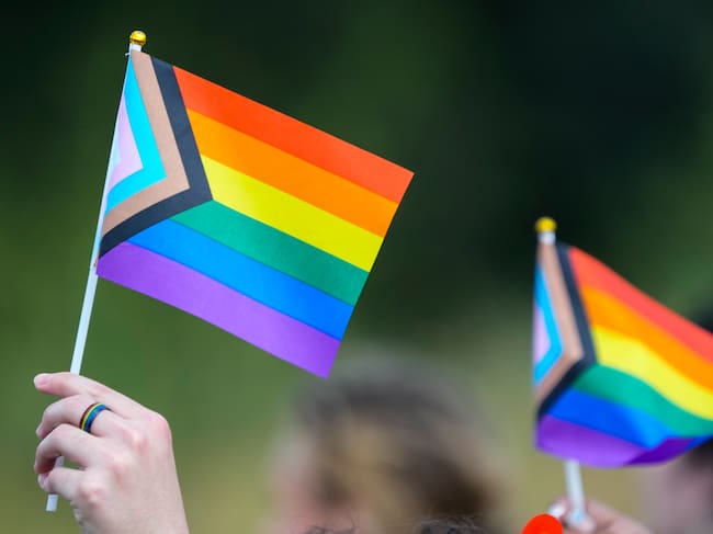 Personas sujetando banderas LGTBIQ+