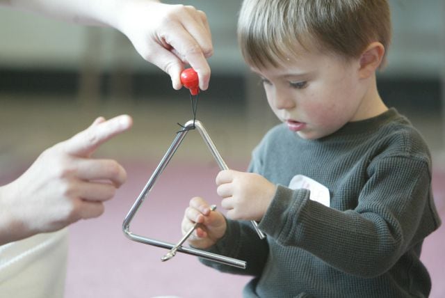 Niño tocando el triángulo.