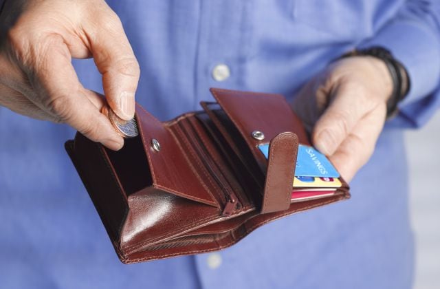 Un hombre cierra mete las monedas en su cartera.