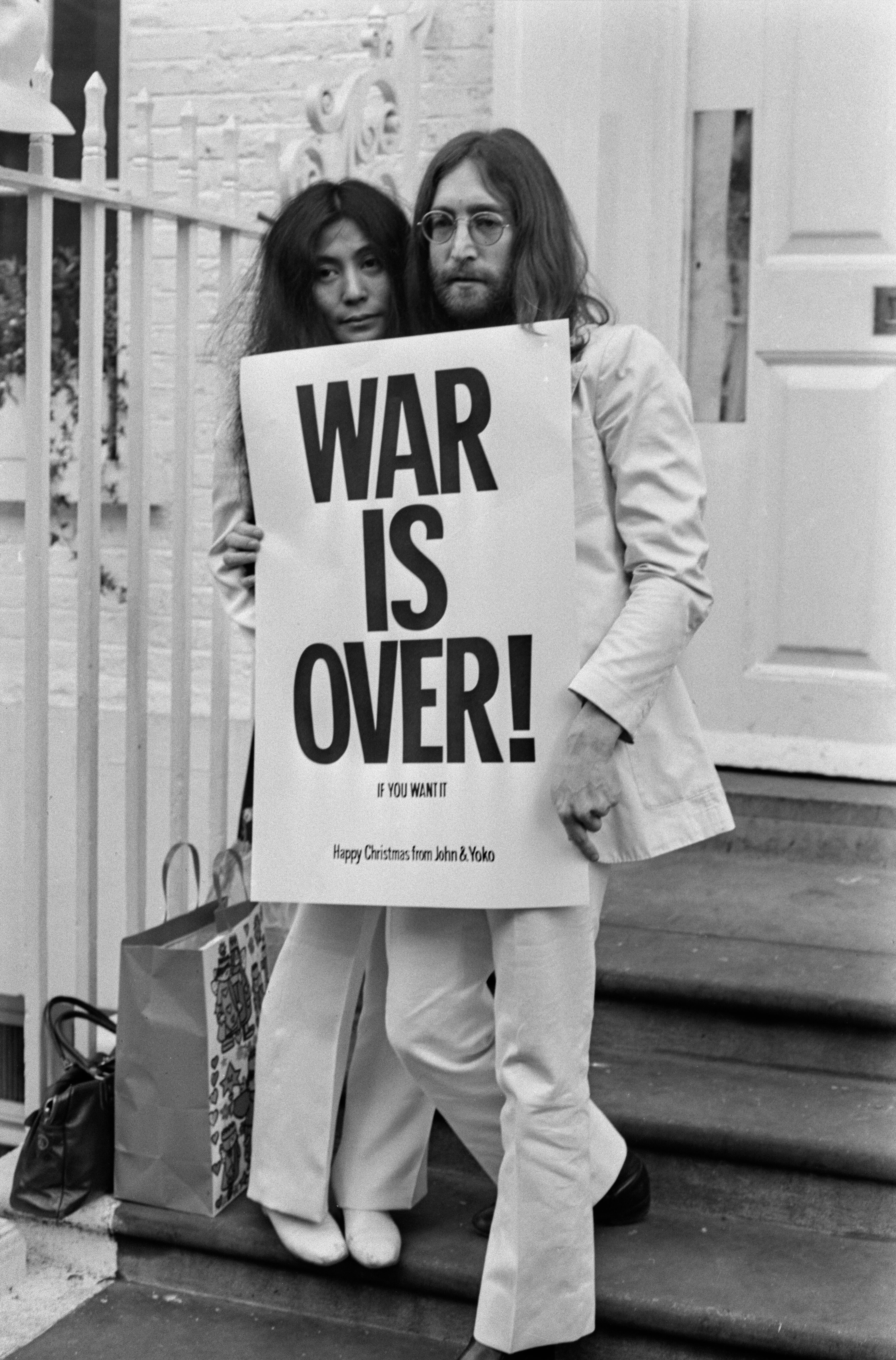 John Lennon (1940-1980) y Yoko Ono posan en las escaleras del edificio de Apple en Londres, sosteniendo uno de los carteles que distribuyeron en las principales ciudades del mundo como parte de una campaña por la paz en protesta contra la guerra de Vietnam. «La guerra ha terminado, si tú quieres». (Foto de Frank Barrett/Keystone/Hulton Archive/Getty Images)