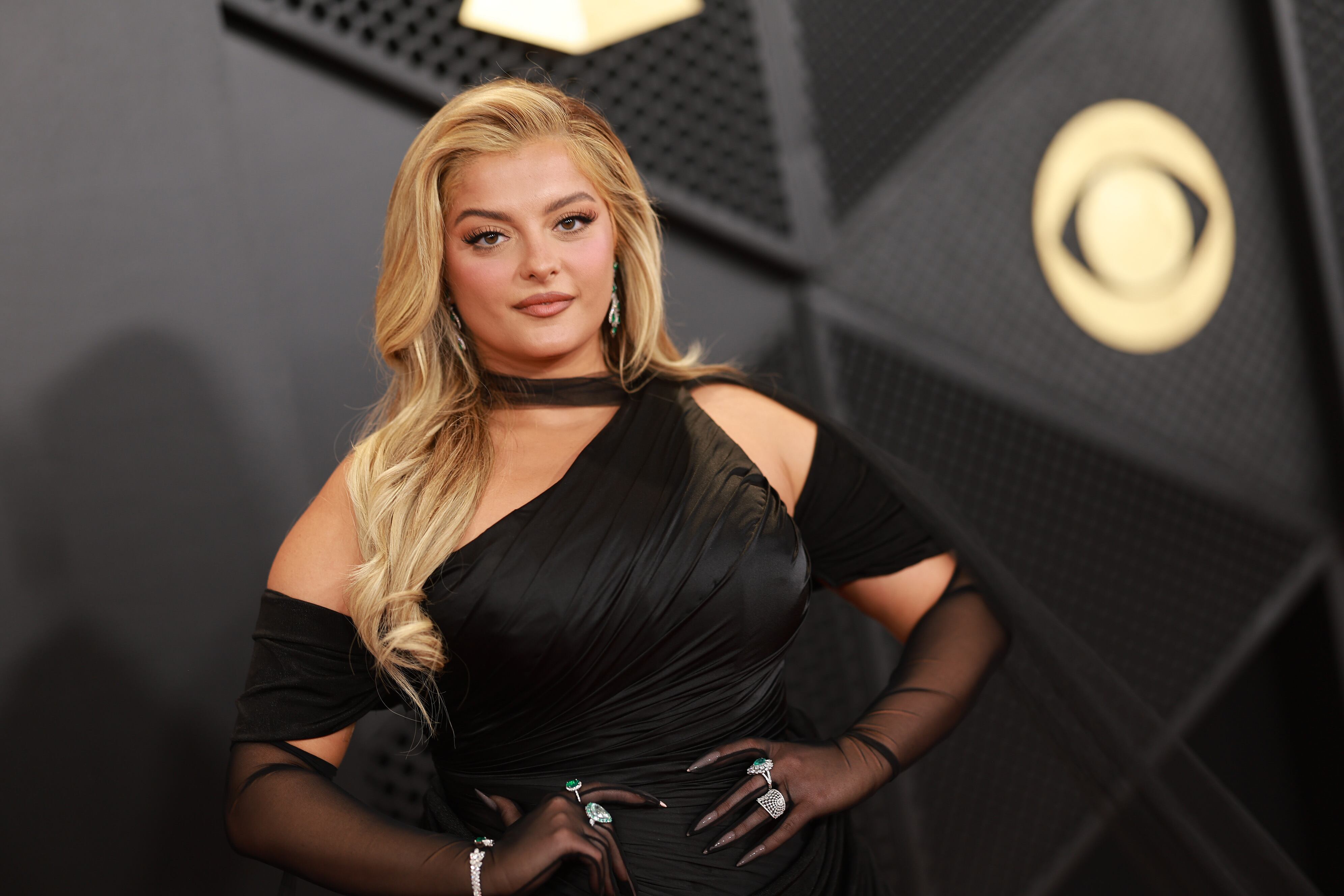 Otra apuesta al negro clásico fue el de Bebe Rexha que jugó con un escote asimétrico y con mangas transparentes.