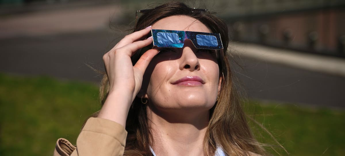 Una mujer observa el eclipse con sus gafas
