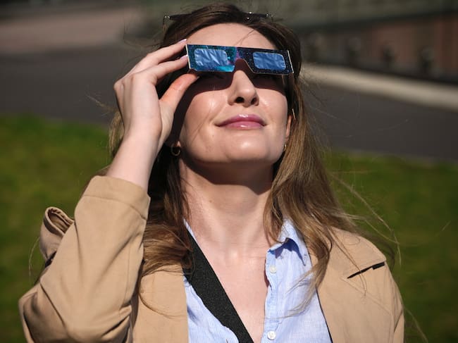 Una mujer observa el eclipse con sus gafas