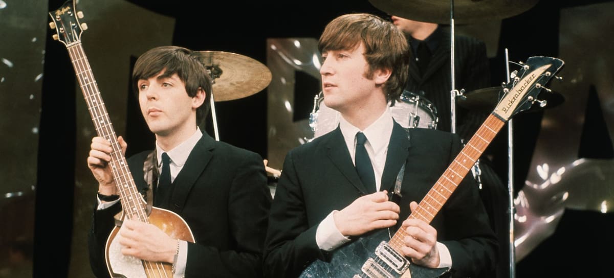 John Lennon y Paul McCartney tocando sus respectivas guitarras en un concierto.