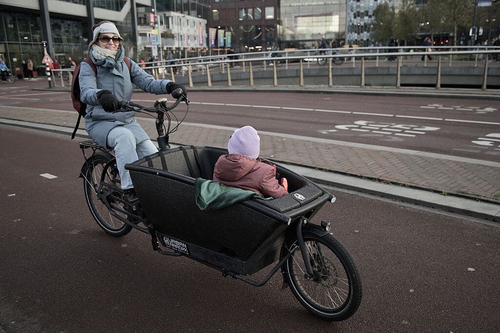 Una mujer lleva a un niño en una bicicleta de carga en Utrecht, Países Bajos.