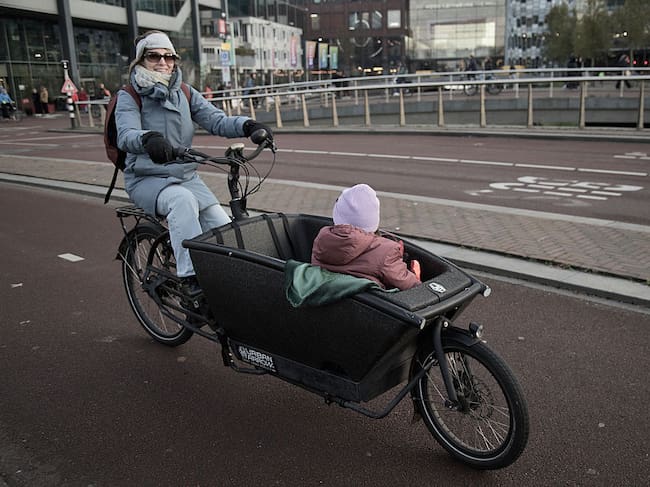 Una mujer lleva a un niño en una bicicleta de carga en Utrecht, Países Bajos.