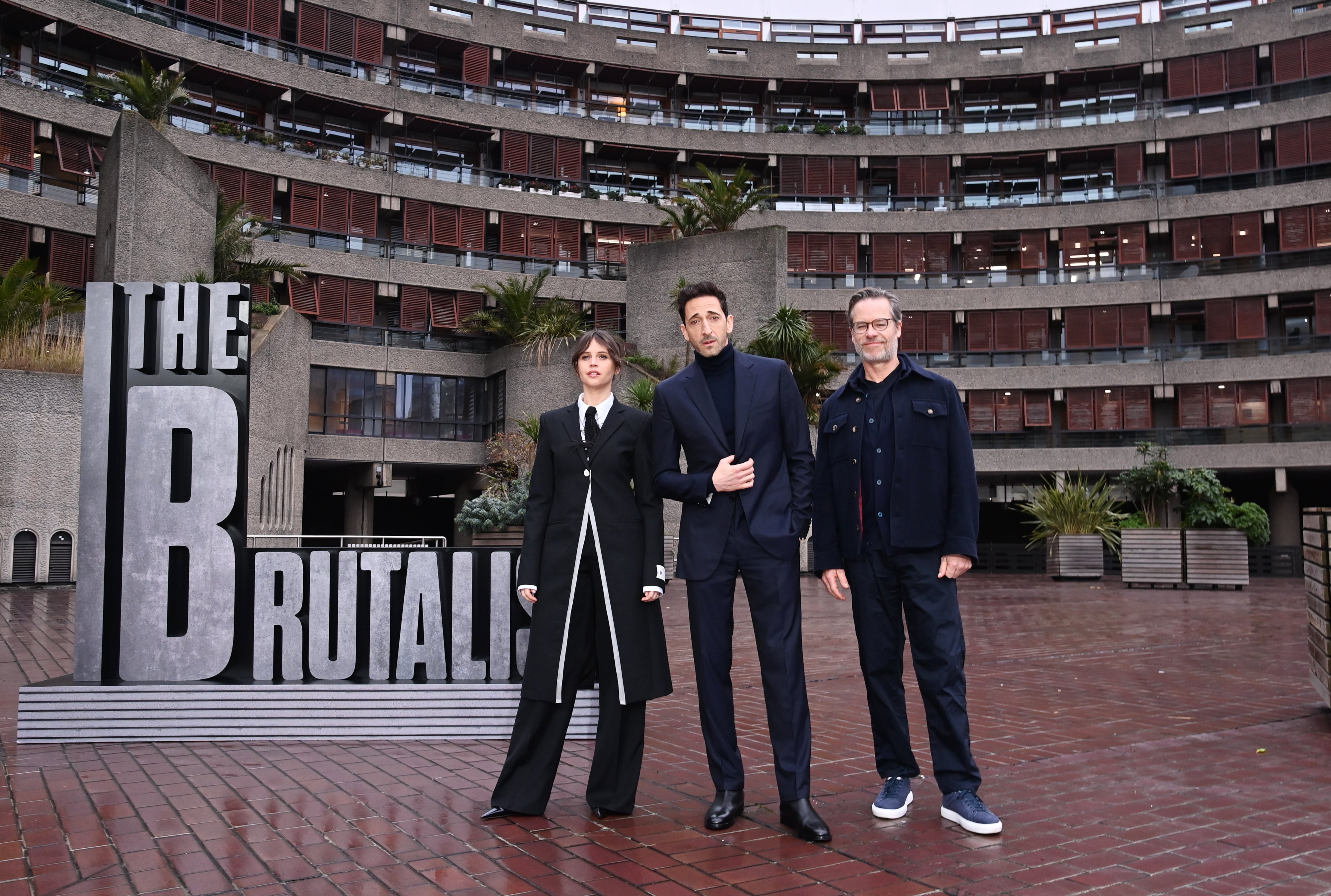 LONDON, ENGLAND - JANUARY 15: (L to R) Felicity Jones, Adrien Brody and Guy Pearce attend the London photocall for &quot;The Brutalist&quot; at Brutalist landmark The Barbican on January 15, 2025 in London, England. (Photo by Alan Chapman/Dave Benett/WireImage)