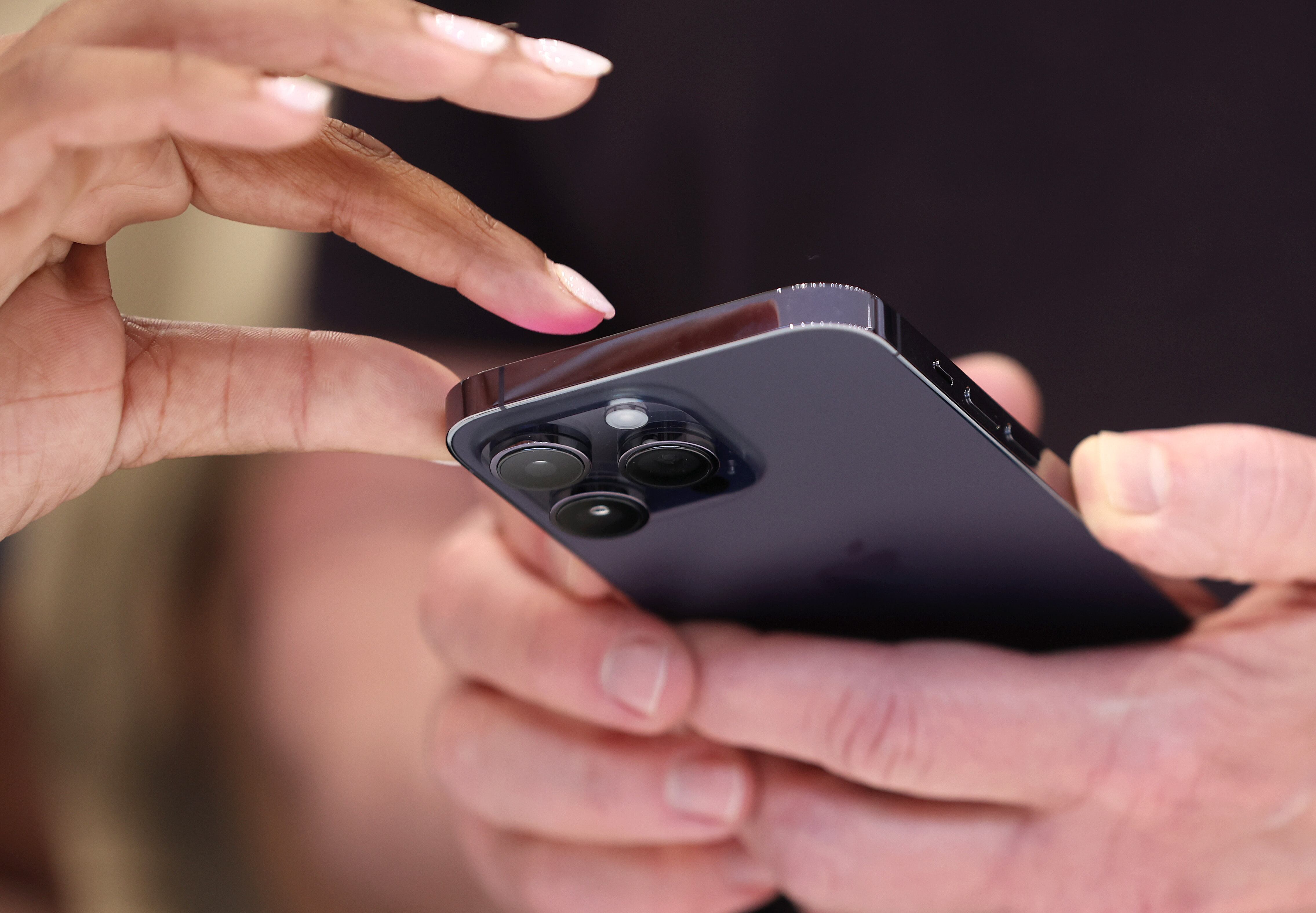 CUPERTINO, CALIFORNIA - SEPTEMBER 07: Attendees examine a brand new iPhone 14 Pro during an Apple special event on September 07, 2022 in Cupertino, California. Apple CEO Tim Cook unveiled the new iPhone 14 as well as new versions of the Apple Watch, including the Apple Watch SE, a low-cost version of the popular timepiece that will start at $249. (Photo by Justin Sullivan/Getty Images)