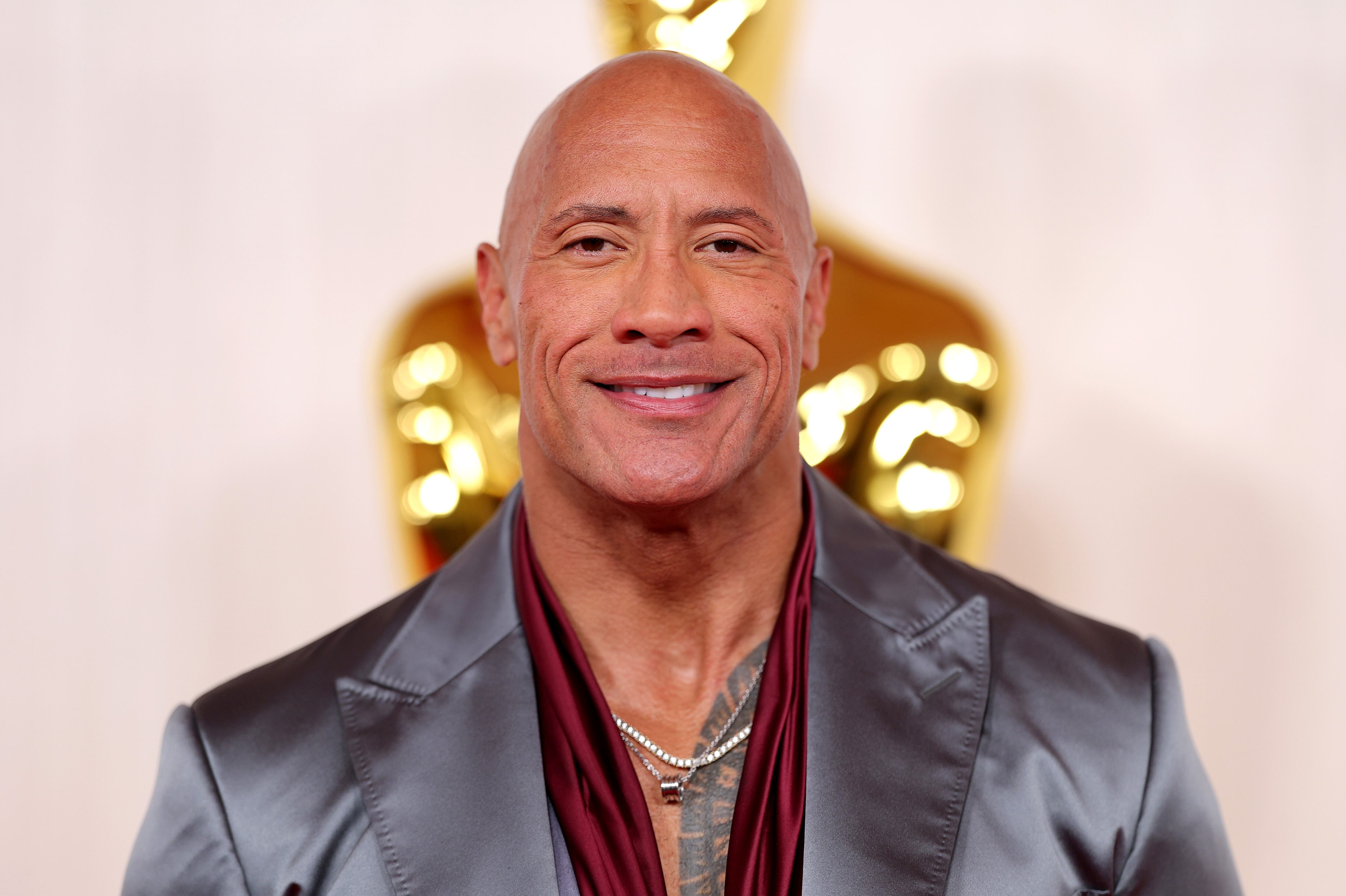 Dwayne 'La Roca' Johnson nunca pasa desapercibido y menos con el traje gris con reflejos y ese toque burdeos, Desde luego personalidad no le falta.