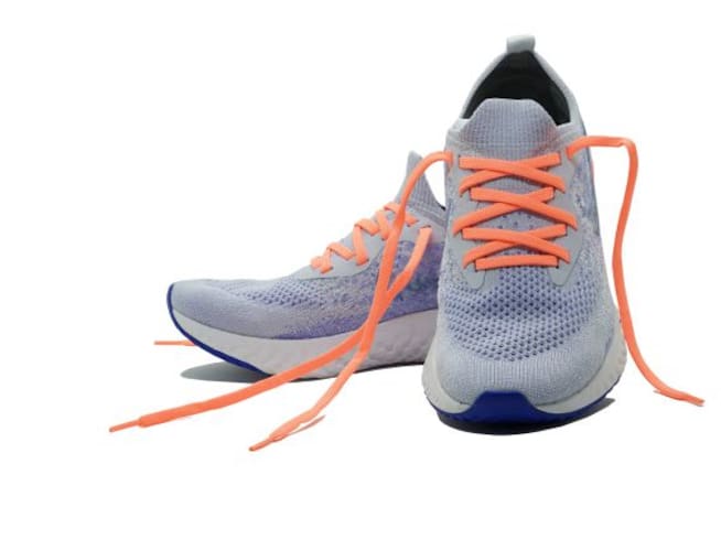 Unas zapatillas de deporte grises con cordones naranjas.