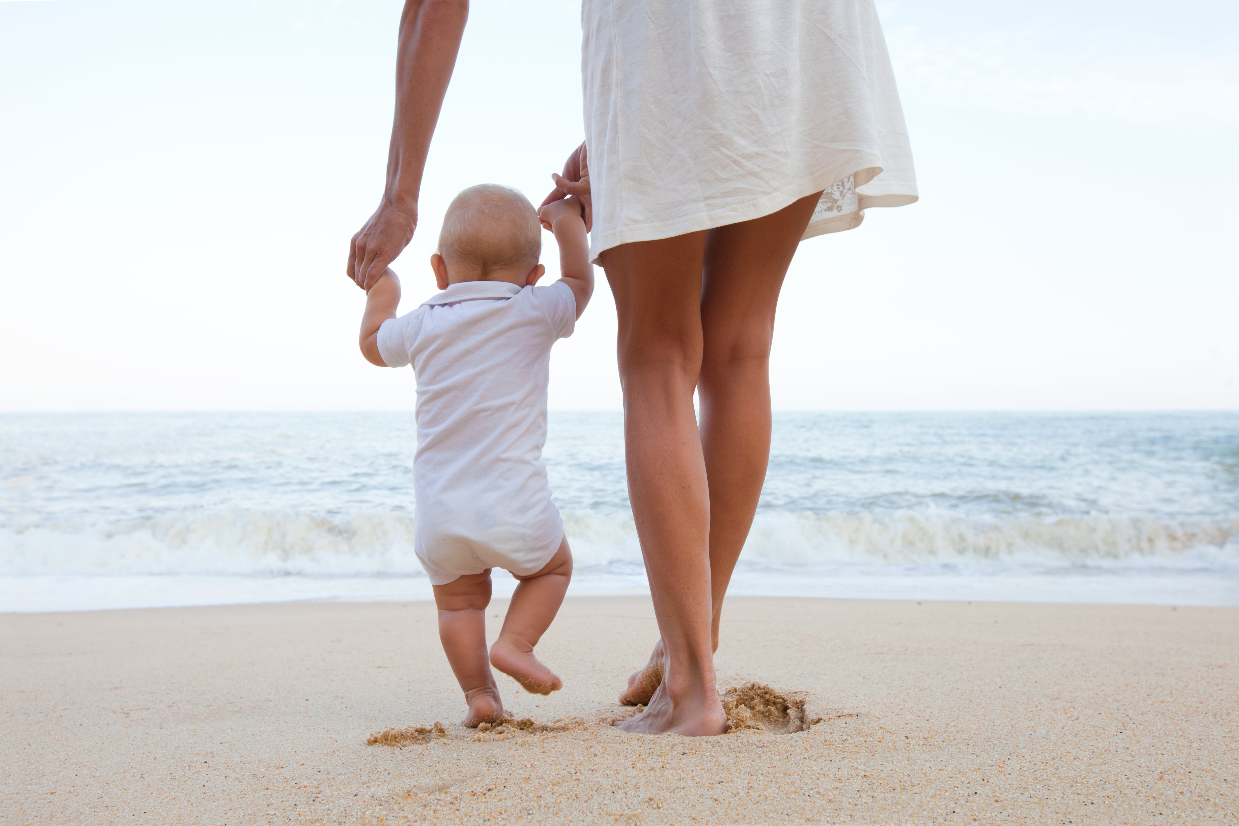 Madre con un bebé en la playa.