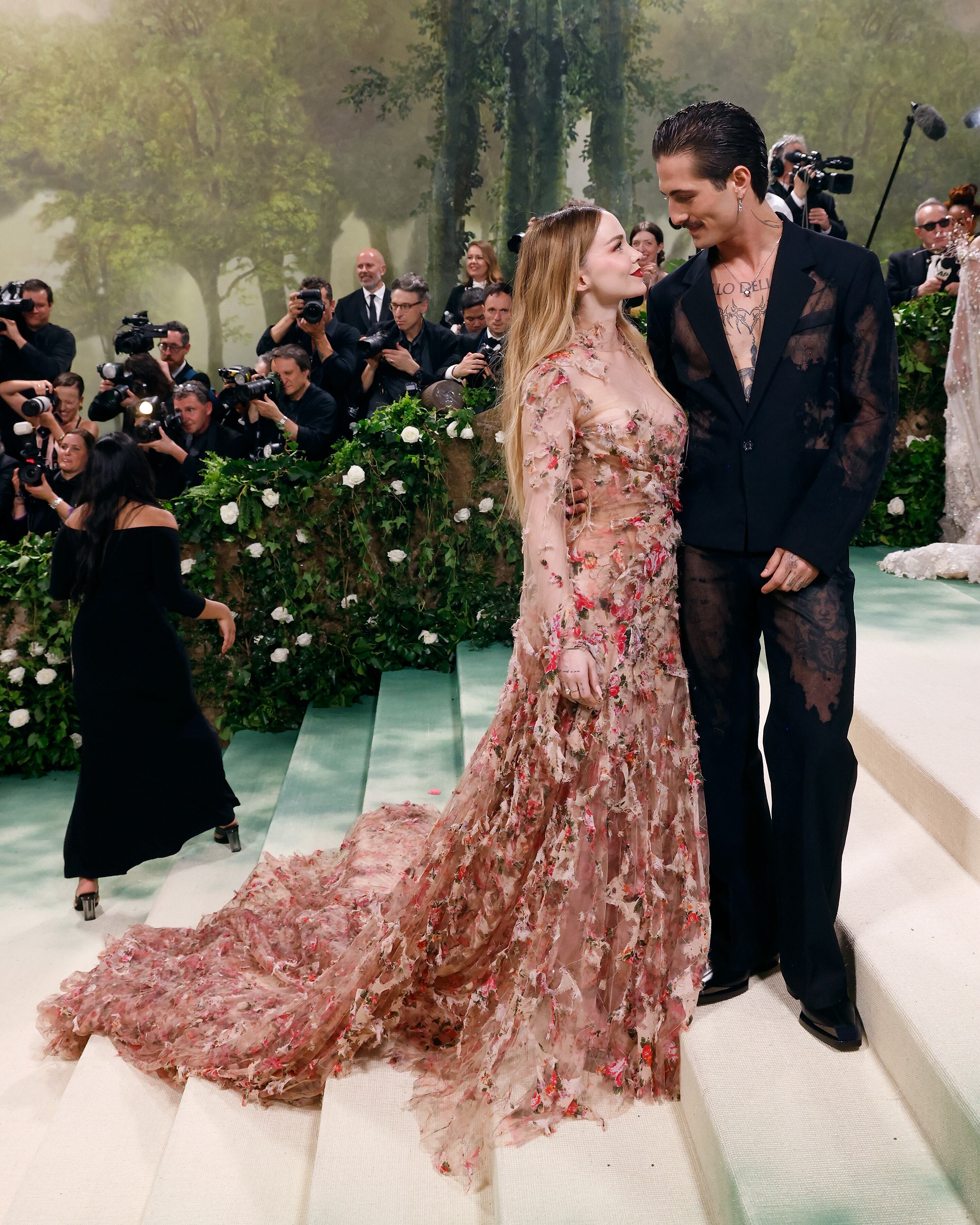 Dove Cameron y Damiano David, el cantante de Maneskin, son pareja desde el pasado noviembre y parece que lo suyo va viento en popa. Ambos escogieron diseños de Diesel para su posado en el Metropolitano de Arte de Nueva York. Ella, llena de flores, y él con un traje negro con recortes de encaje sin camiseta ni camiseta, que le permitió mostrar el piercing de su pezón.