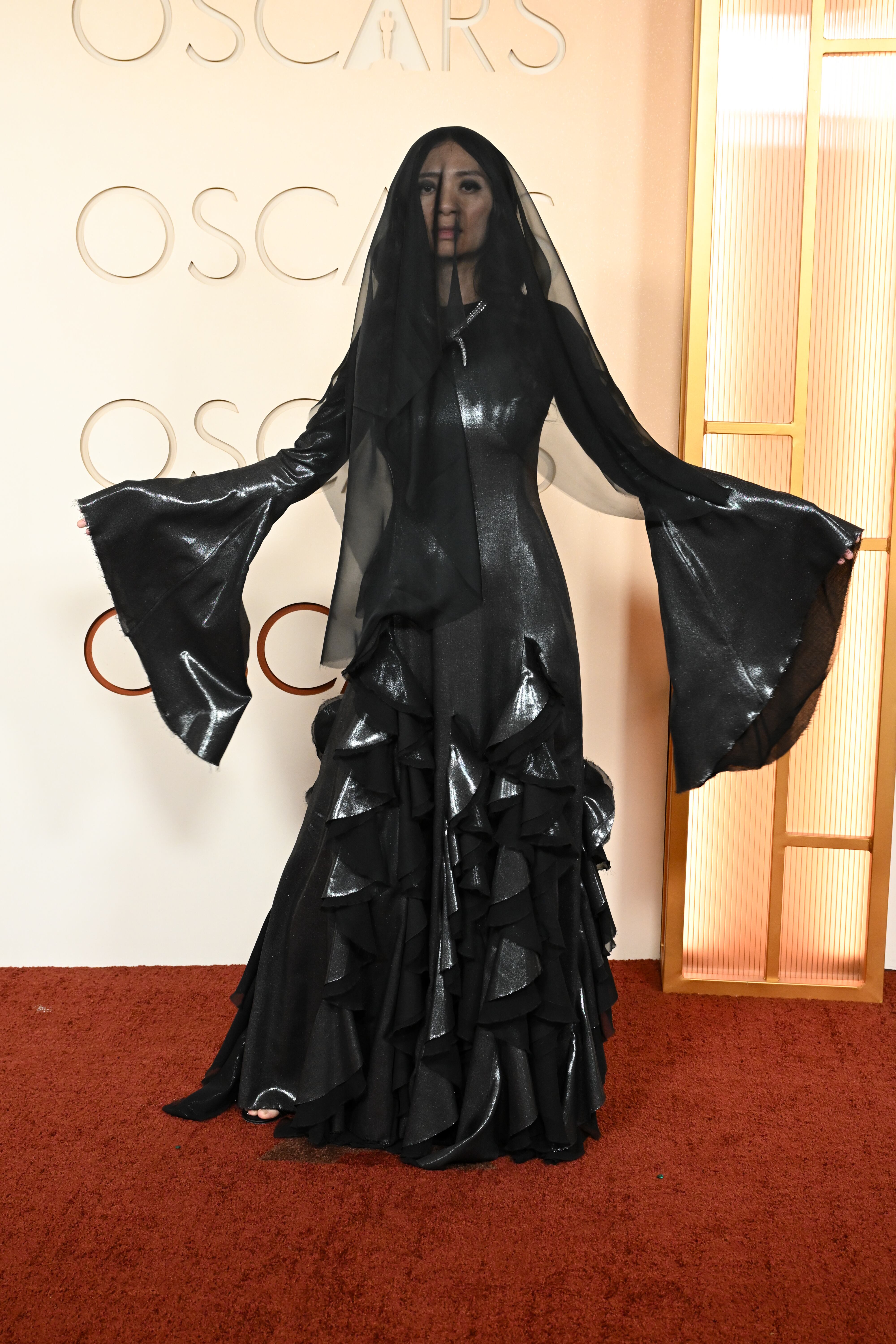 La directora de Hamnet, la única mujer que opta a la estatuilla a mejor dirección, ha sorprendido con un look a lo viuda negra con ese vestido completamente negro con manga murciélago y volantes en la falda. No le ha faltado ni el velo tapándole la cara.