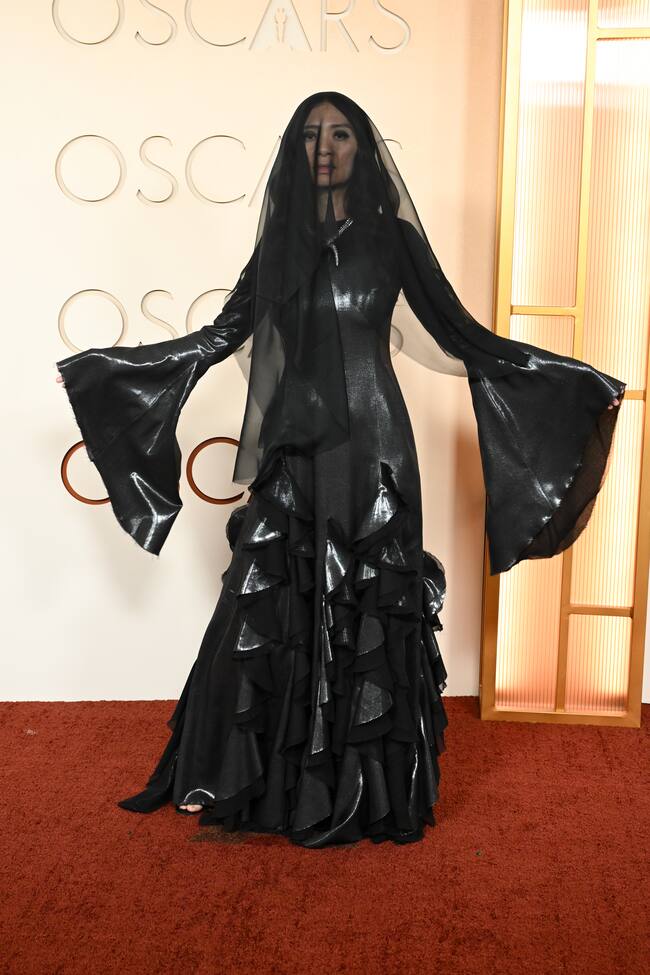 La directora de Hamnet, la única mujer que opta a la estatuilla a mejor dirección, ha sorprendido con un look a lo viuda negra con ese vestido completamente negro con manga murciélago y volantes en la falda. No le ha faltado ni el velo tapándole la cara.