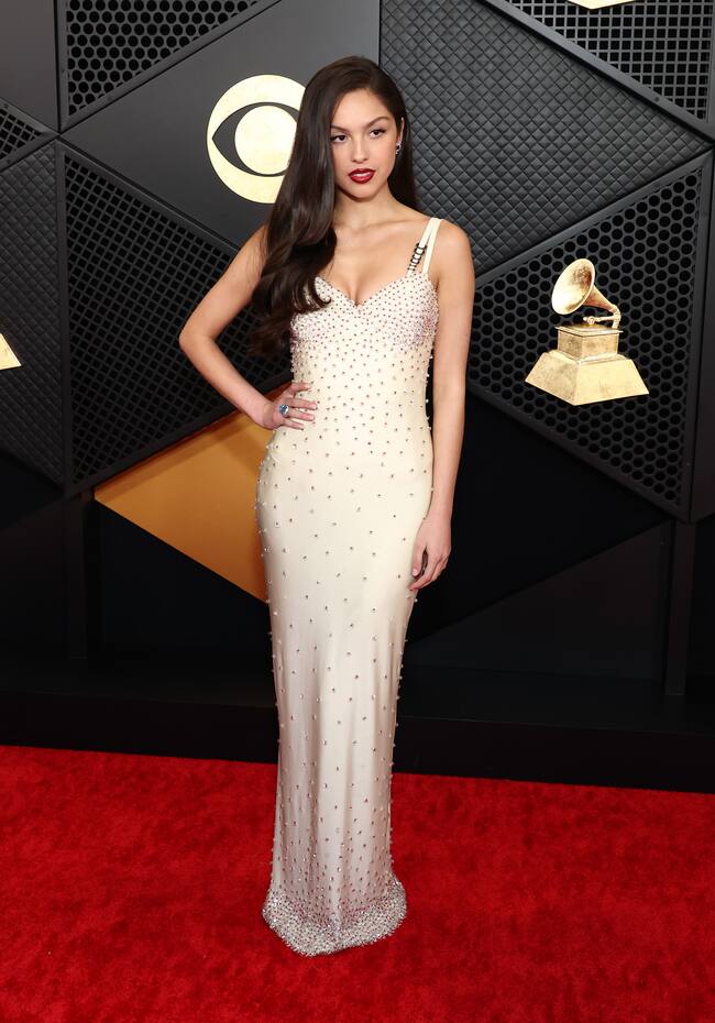 Olivia Rodrigo apostó por el color blanco predominante en las grandes figuras musicales pero con un toque diferente gracias a los minicristales bordados en su vestido de Versace. Su escote en forma de corazón y su pelo largo suelto de estilo clásico completan el conjunto. ¡Wow!