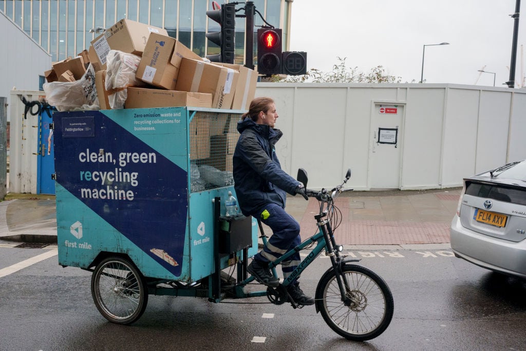 Un empleado de limpieza, en una bicicleta de carga en Londres.