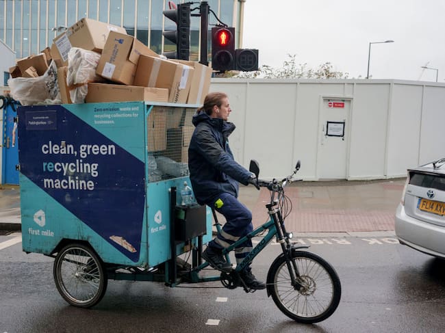 Un empleado de limpieza, en una bicicleta de carga en Londres.