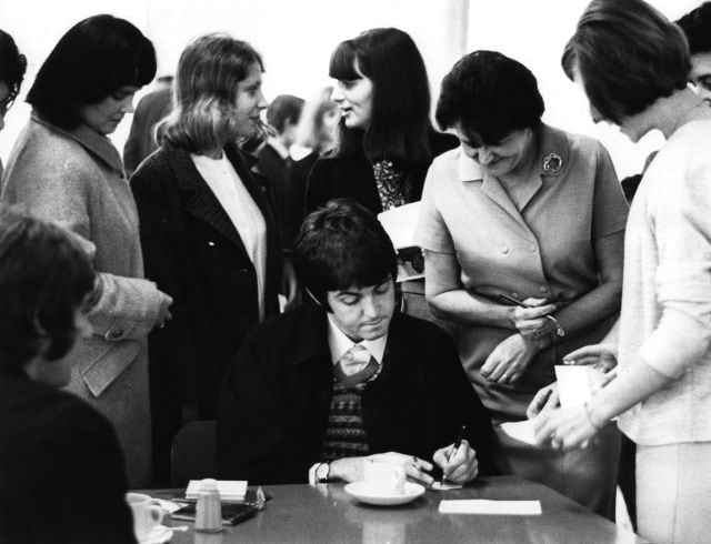 Paul McCartney, el cantante y guitarrista de The Beatles, firmando autógrafos en un encuentro con fans en Londres en 1967.