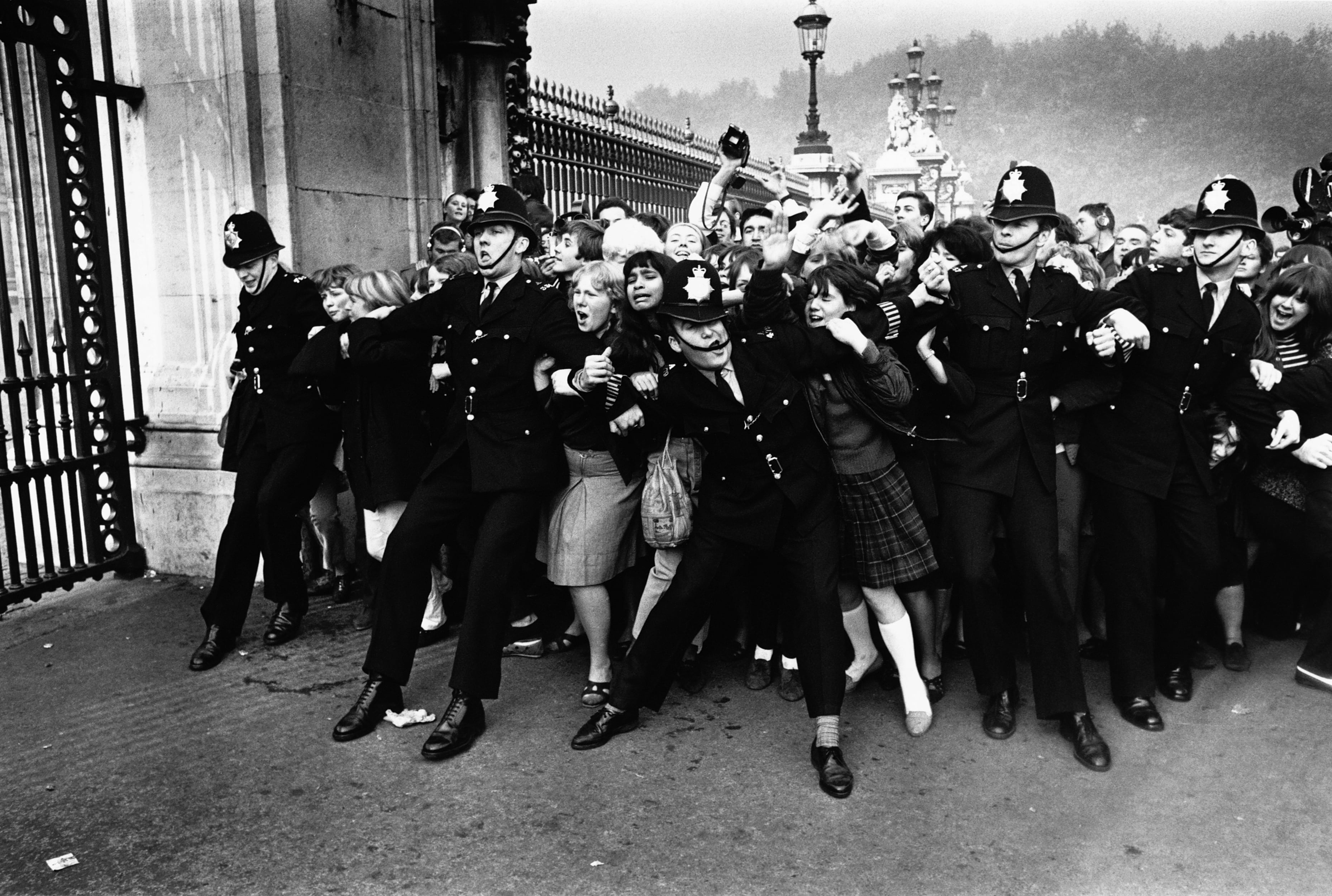 La policía trata de contener a las fans de The Beatles a las puertas del palacio de Buckingham el 26 de octubre de 1965.