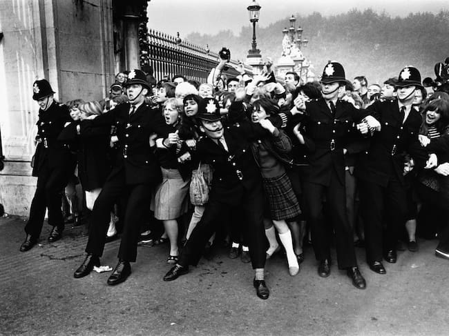 La policía trata de contener a las fans de The Beatles a las puertas del palacio de Buckingham el 26 de octubre de 1965.