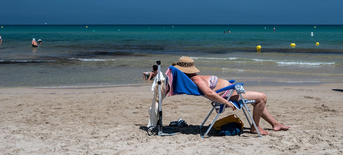 Una mujer trata toma el sol en la playa